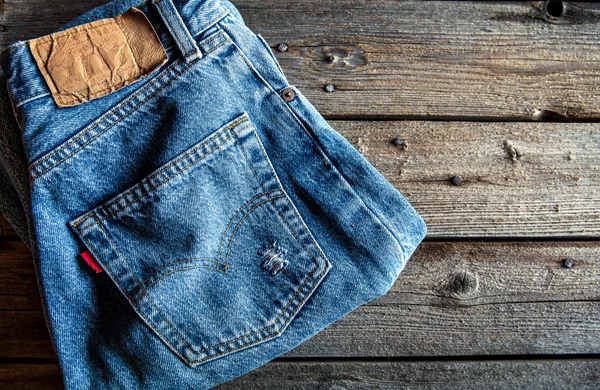 Neatly folded jeans on wooden background. Clothing, fashion, sty — Stock Photo, Image