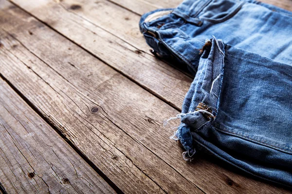 Jeans auf einem hölzernen Hintergrund. der obere Teil. Kleidung, Mode, Stil, Lebensstil — Stockfoto