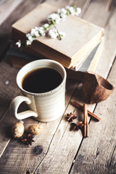 Большая чашка кофе на винтажном деревянном фоне. Весенние цветы и книги . — стоковое фото