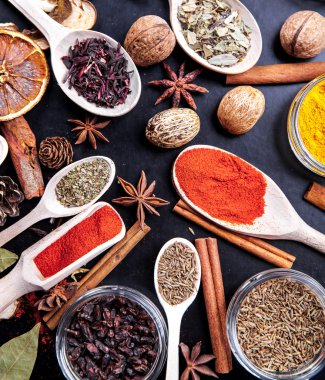 siyah arka plan üzerine baharat ile tahta kaşıklar