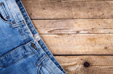 Ahşap arka plan üzerinde kot pantolon. Üst kısmı. Giyim, moda, Stil, yaşam biçimi