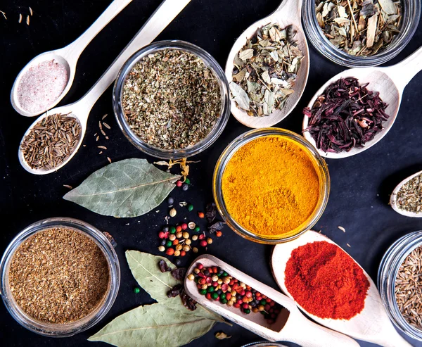 Spices on black background in special jars. Food — Stock Photo, Image