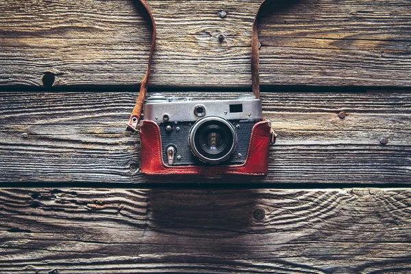 Cámara retro sobre fondo de mesa de madera, tono de color vintage — Foto de Stock