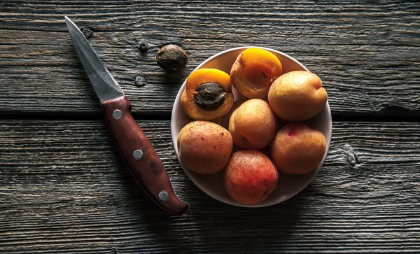 Fruta deliciosa. Damascos com uma faca em um fundo de madeira. Estilo country. Alimentos — Fotografia de Stock