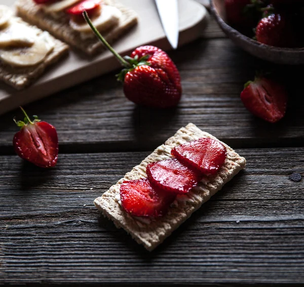 Fruktig toast på trä bakgrund. Jordgubbar, bröd, smör och ost. Vintage stil — Stockfoto