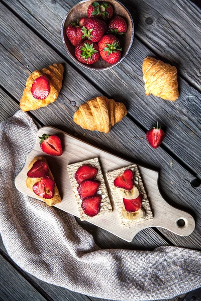 En läcker frukost med jordgubbar och bröd på trä bakgrunds — Stockfoto