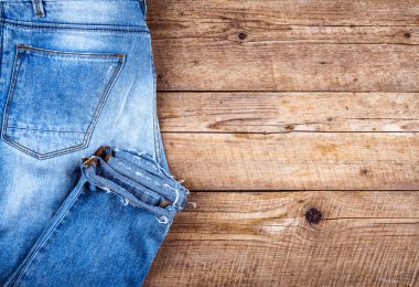 Şık kot bir ahşap arka plan üzerinde katlanmış. Giyim, moda, yaşam biçimi.