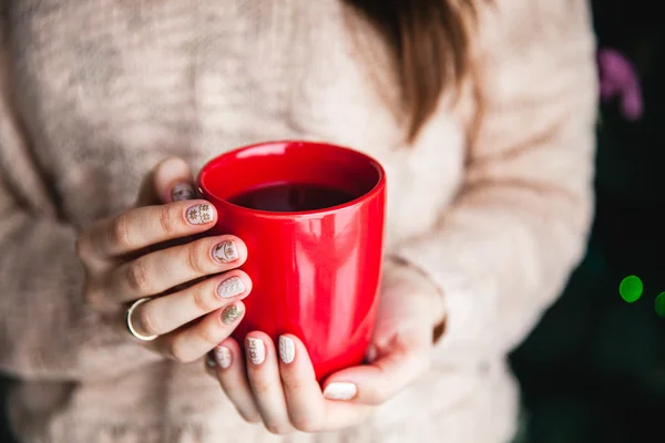 Frau hält eine rote Tasse Kaffee in der Hand. mit einer schönen Winter-Maniküre. Trinken, Mode, Morgen — Stockfoto