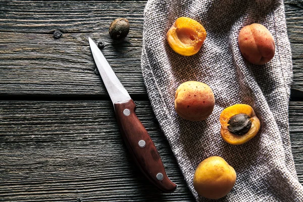 Frische Aprikosen mit einem Messer auf einem Küchentuch. Holzuntergrund. Obst, Lebensmittel — Stockfoto