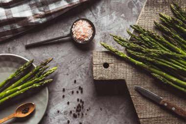 Kesme tahtasındaki kuşkonmaz. Sağlıklı yiyecekler, somut bir zeminde sağlık..