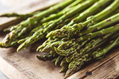 Kesme tahtasındaki kuşkonmaz. Sağlıklı yiyecekler, somut bir zeminde sağlık..