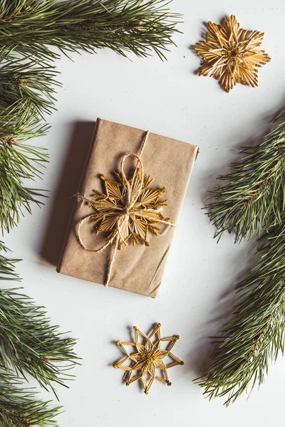 Confezione regalo con cornice verde natalizia e pigne su sfondo bianco. Copia spazio e vista dall'alto — Foto Stock