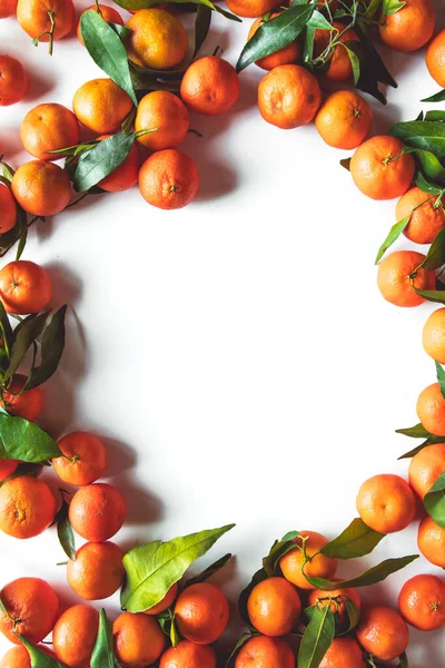 Orangen-Frucht-Komposition mit grünen Blättern und Scheiben auf weißem Holzhintergrund, Ansicht von oben — Stockfoto