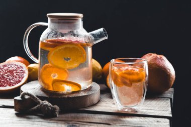 Şeffaf bir çaydanlıkta çay ve bir bardak, ahşap zeminde sağlıklı bir içecek..