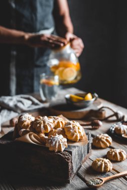 Adam taze greyfurt dilimleriyle ahşap tablete sıcak çay koyuyor. Sağlıklı içecek, Eco, vegan..