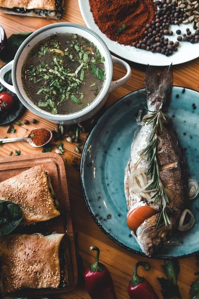 Свежая рыба дорадо. Дорадо и ингредиенты для приготовления пищи на столе. — стоковое фото