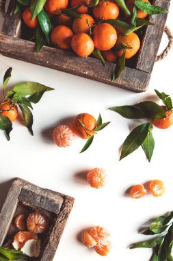 Tahta kutuda taze yaprakları olan mandalinalar beyaz kutuda izole edilmiş, beyaz bir kutuda izole edilmiş.