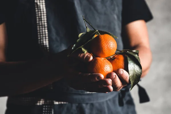 Спелые сладкие апельсиновые мандарины в человеческой руке — стоковое фото