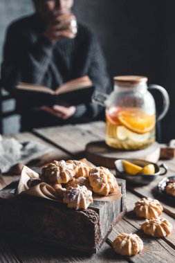 Kadın kitap okuyor ve taze greyfurtlu sıcak çay içiyor. Sağlıklı içecek, Eco.