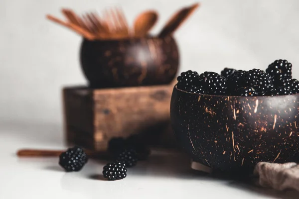 Brombeeren in Kokosnussschalen mit Kokoslöffel und Gabel. — Stockfoto