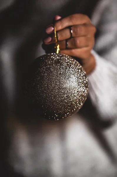 Mujer en suéter caliente sosteniendo juguete bola decorativa de vidrio en las manos, espacio de copia. Navidad, fiesta de año nuevo — Foto de Stock