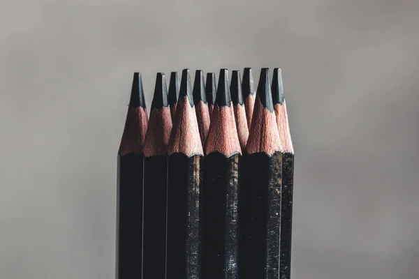 Enkla grafitpennor på grå bakgrund. Svarta pennor — Stockfoto