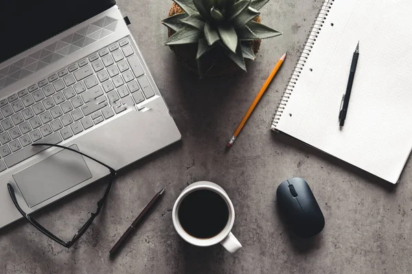 Portátil y libro, café sobre fondo gris, vista superior del escritorio de la oficina con textura — Foto de Stock