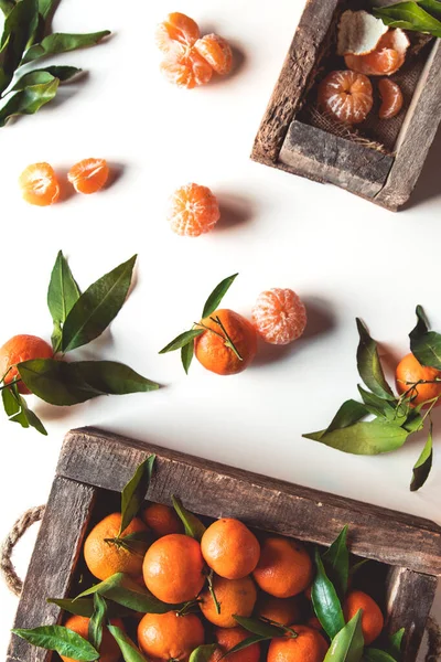 Mandarinen mit frischen Blättern in Holzkiste isoliert auf weiß, isoliert auf weiß — Stockfoto