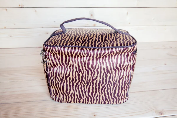 Beautiful cosmetic bag for traveling on a wooden background — Stock Photo, Image