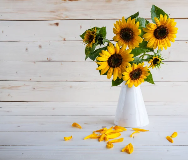 A bouquet of autumn sunflowers in a vase on a grungy wooden table. — Stock Photo, Image