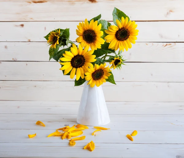 Girasoles en un jarrón sobre un fondo rústico y gris — Foto de Stock