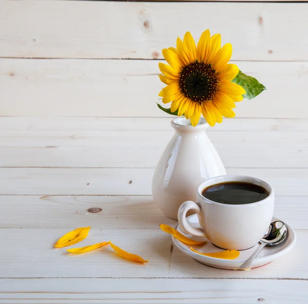 Sonnenblume und eine Tasse Kaffee auf einem Holzgrund — Stockfoto