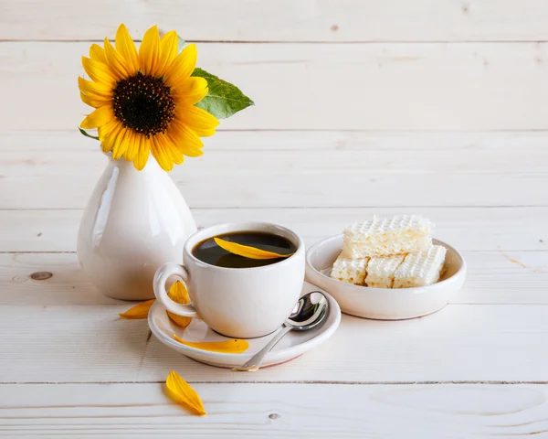 Girasole e una tazza di caffè su uno sfondo di legno — Foto Stock