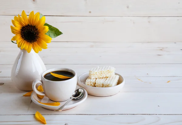 Girasole e una tazza di caffè su uno sfondo di legno — Foto Stock