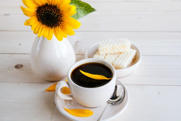 Girasole e una tazza di caffè su uno sfondo di legno — Foto Stock