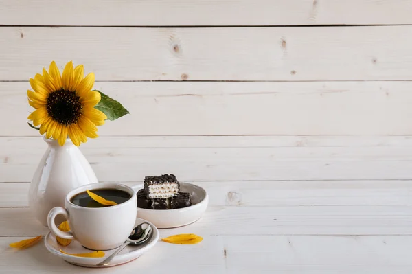 Sonnenblume und eine Tasse Kaffee auf einem Holzgrund — Stockfoto