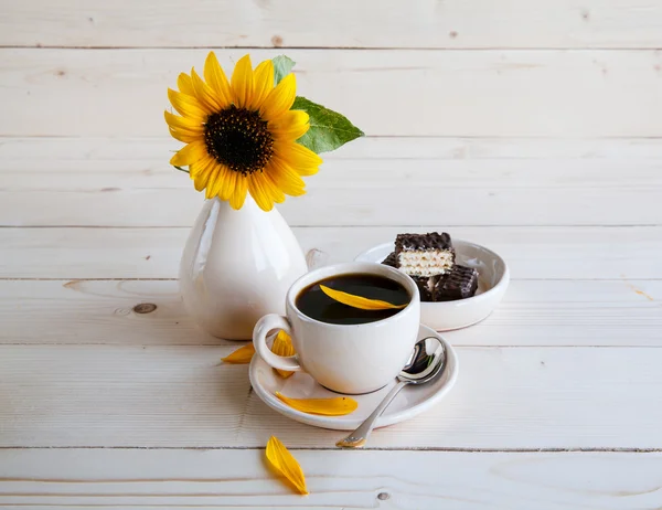 Kopje koffie op zonnebloemen achtergrond — Stockfoto