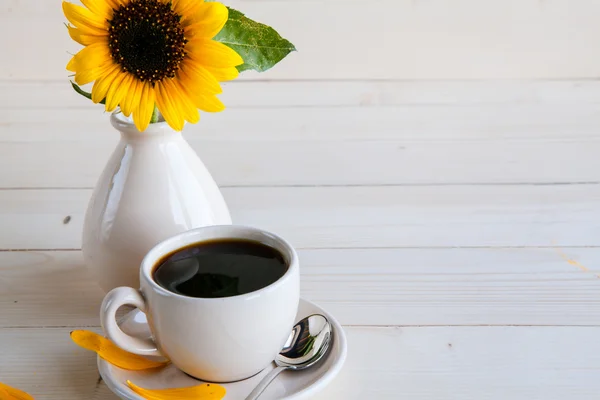 Tournesol et une tasse de café sur un fond en bois — Photo