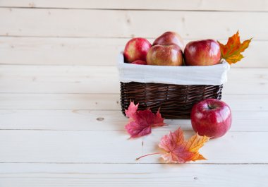 Tahta arka planda kırmızı elmalar olan sepet.