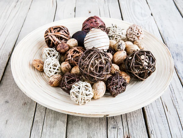 Decorative twig spheres lay in wooden bowl on wooden table — Stock Photo, Image