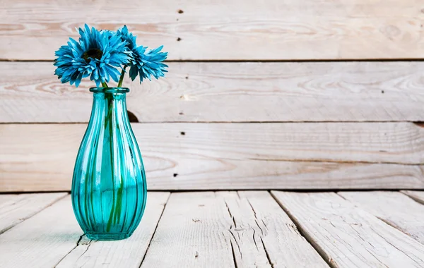 Flor de gerberas azules en un jarrón sobre fondo de madera — Foto de Stock