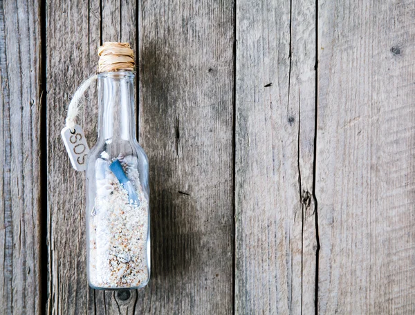 Message in a bottle on a wooden background — Stock Photo, Image