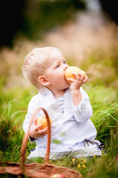 Bambino con un cesto e lo mangia con frutta — Foto Stock