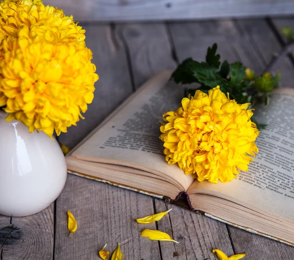 Fiori. Bellissimo crisantemo giallo in un vaso vintage. Una tazza di caffè. Servais luminoso, tazza e piattino.. Bella colazione. Vecchi libri su uno sfondo di legno . — Foto Stock