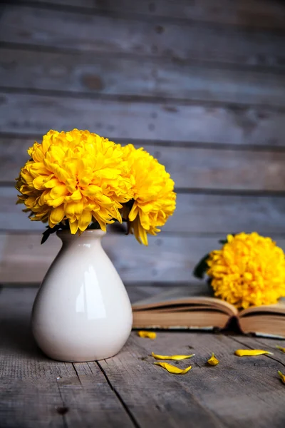 Flowers. Beautiful yellow chrysanthemum in a vintage vase. Cup of coffee. Bright Servais, cup and saucer .. Beautiful breakfast.Old books on a wooden background. — Stock Photo, Image