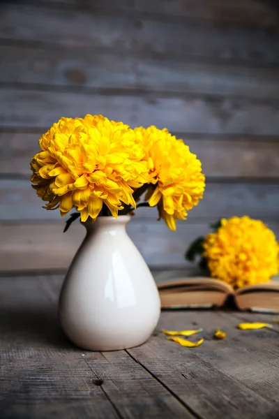 Flowers. Beautiful yellow chrysanthemum in a vintage vase. Cup of coffee. Bright Servais, cup and saucer .. Beautiful breakfast.Old books on a wooden background. — Stock Photo, Image