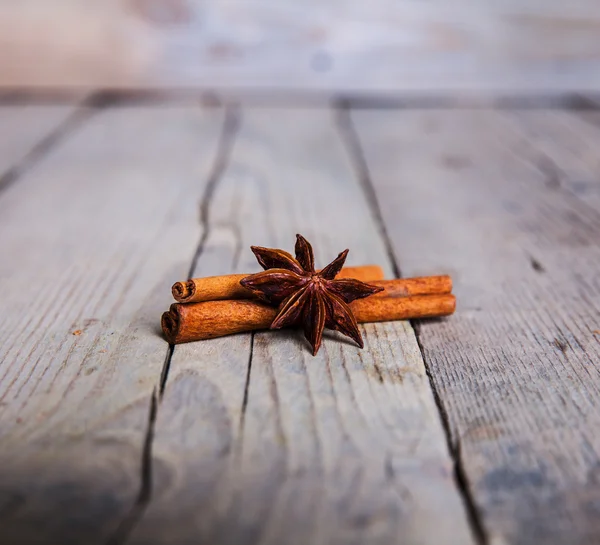 Close-up de anis estrela e pau de canela agrupados em costas de madeira — Fotografia de Stock