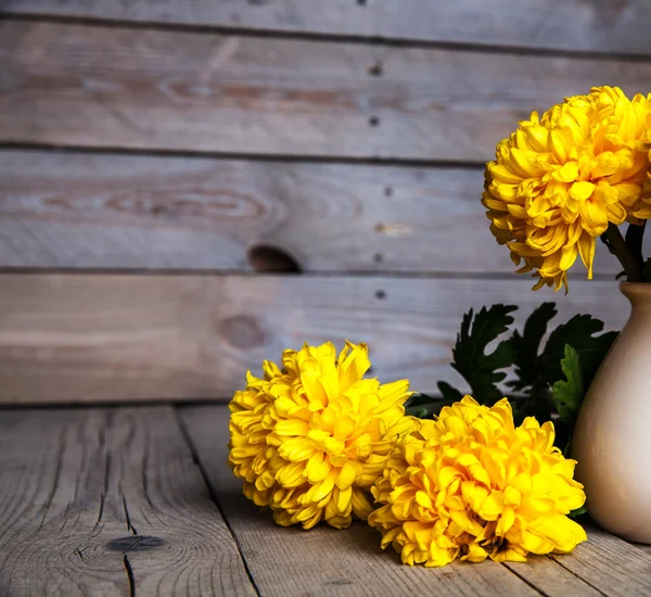 Flowers. Beautiful yellow chrysanthemum in vintage pottery vase. Old wooden background — Stock Photo, Image