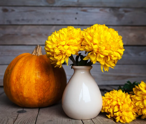 Flores. Hermoso crisantemo amarillo en jarrón de cerámica vintage con calabaza. Antiguo fondo de madera —  Fotos de Stock