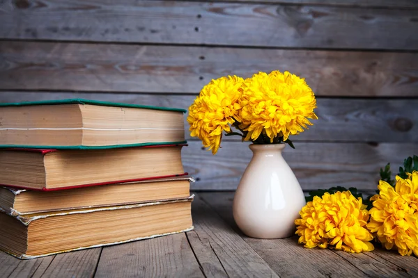 鲜花。美丽的黄色的菊花在一个古董花瓶。一杯咖啡。明亮的 Servais、 杯子和碟子。美丽的早餐。旧书上木制的背景. — 图库照片